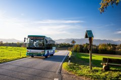 Der Bus der Linie X970 fährt vor der Alpenkulisse im Landkreis Bad Tölz-Wolfratshausen (©Landratsamt Bad Tölz-Wolfratshausen, Simon Schneider)